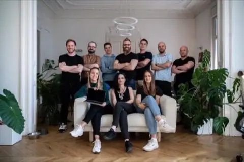 Az Exalt Interactive design-csapata tágas, növényekkel teli irodában; tizenegy ember, Klein Péter a hátsó sor közepén.